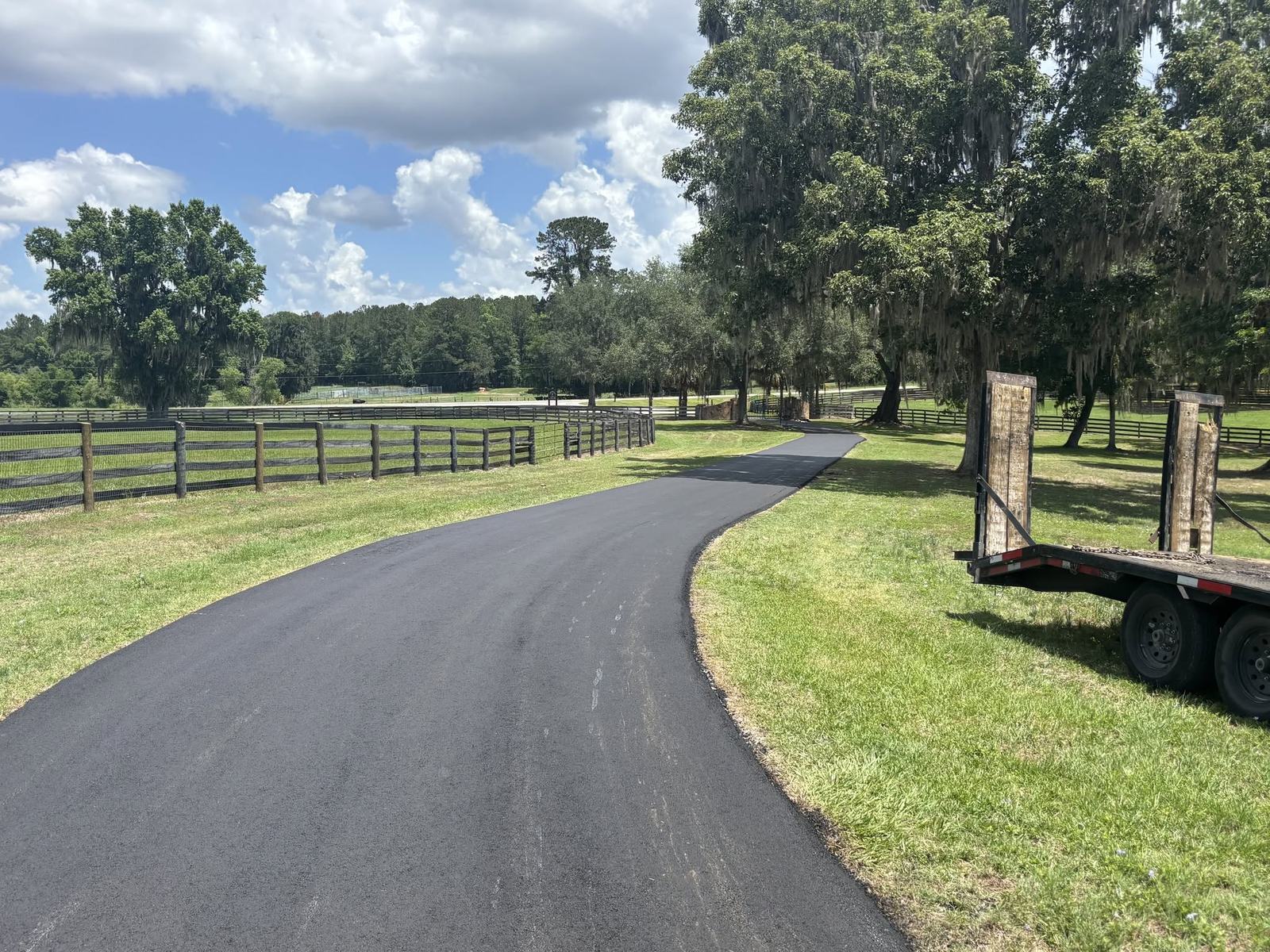Long paved farm drive between paddock fences near Ocala