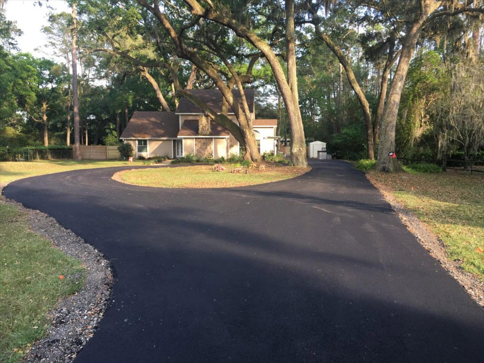 Freshly paved circular driveway under Gainesville oaks